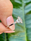 Close-up of the marquise diamond ring showing the prong set center stone and side stones