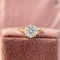 Round lab grown diamond engagement ring displayed in a jewelry box with smooth fabric lining