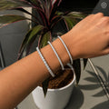 Woman wearing the flexible diamond bangle stacked with other bracelets for a layered look