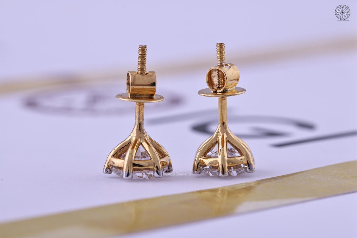 Pair of round cut diamond solitaire studs photographed in natural sunlight
