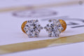 Round lab grown diamond earrings shown alongside the smooth fabric pouch