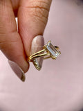 Emerald cut diamond ring presented in its jewelry box with smooth fabric lining