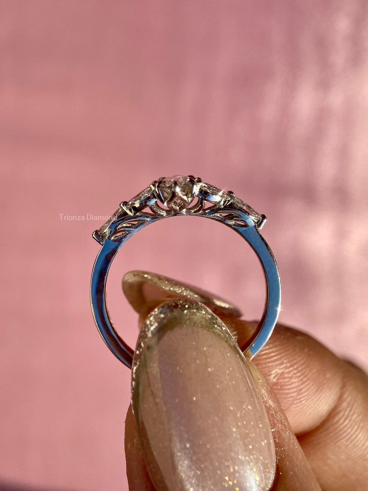 Close-up of the marquise diamond cluster ring showing prong set side stones