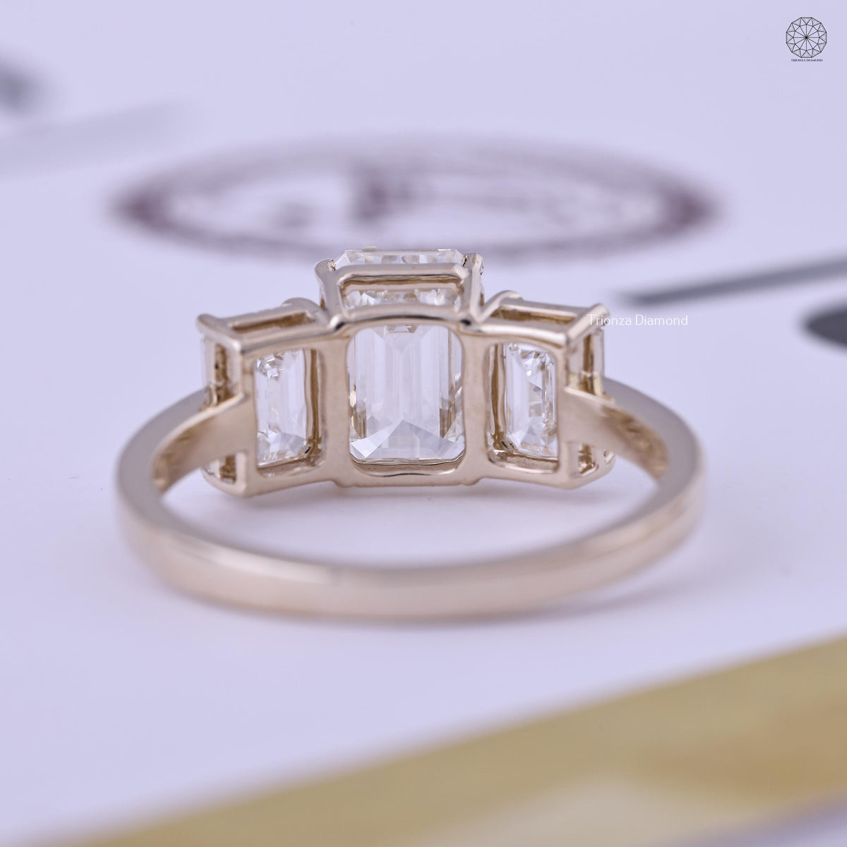 Woman wearing the emerald cut three stone ring, close-up on her hand