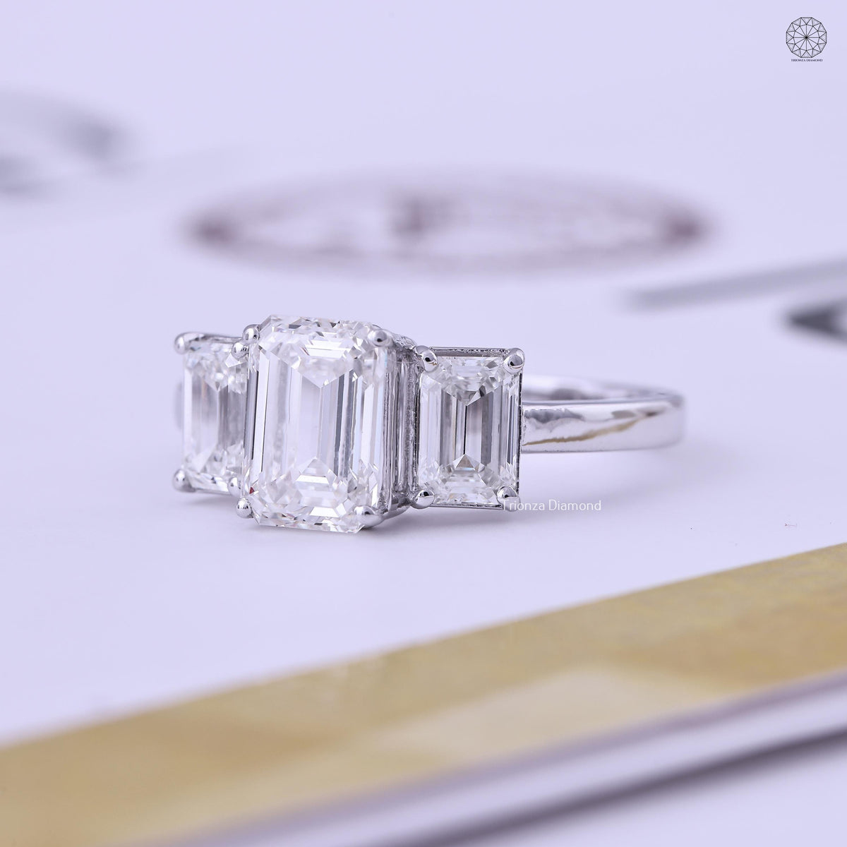 Platinum anniversary ring displaying the three-stone emerald cut diamond design in detail