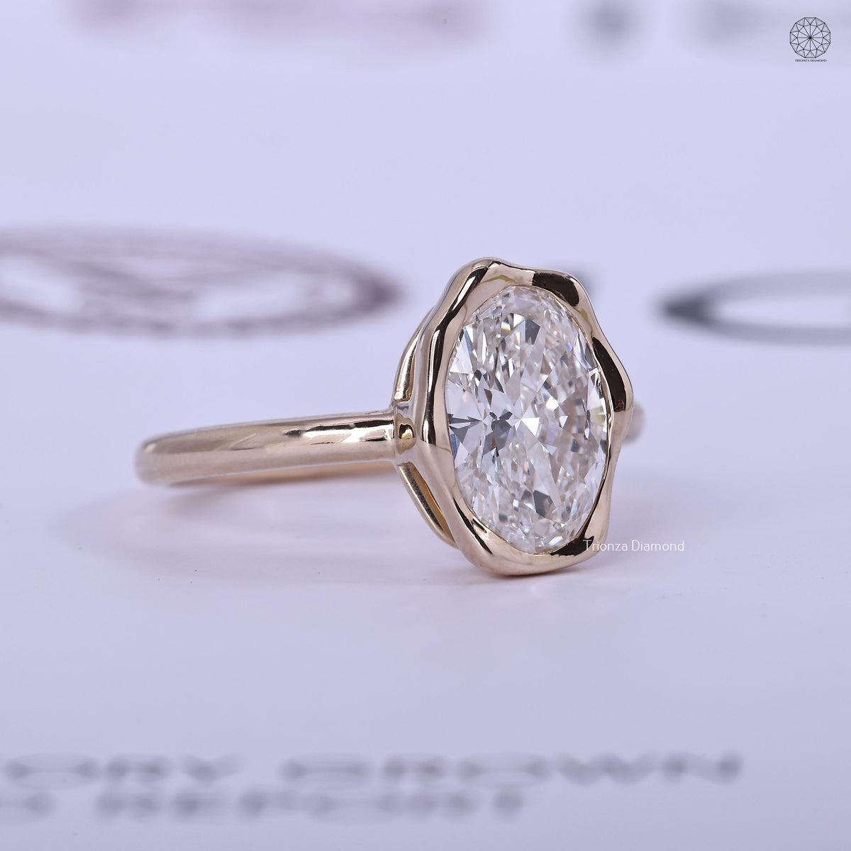 Modern bridal ring featuring a 3 carat oval lab grown diamond in yellow gold