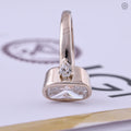 Pear cut side stones flanking the elongated cushion center diamond in this three stone ring