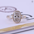 Elongated cushion cut lab grown diamond ring with bezel setting and pear shaped side stones