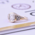 Close-up of the flush set trapezoid side stones surrounding the 2.5Ct cushion cut center diamond