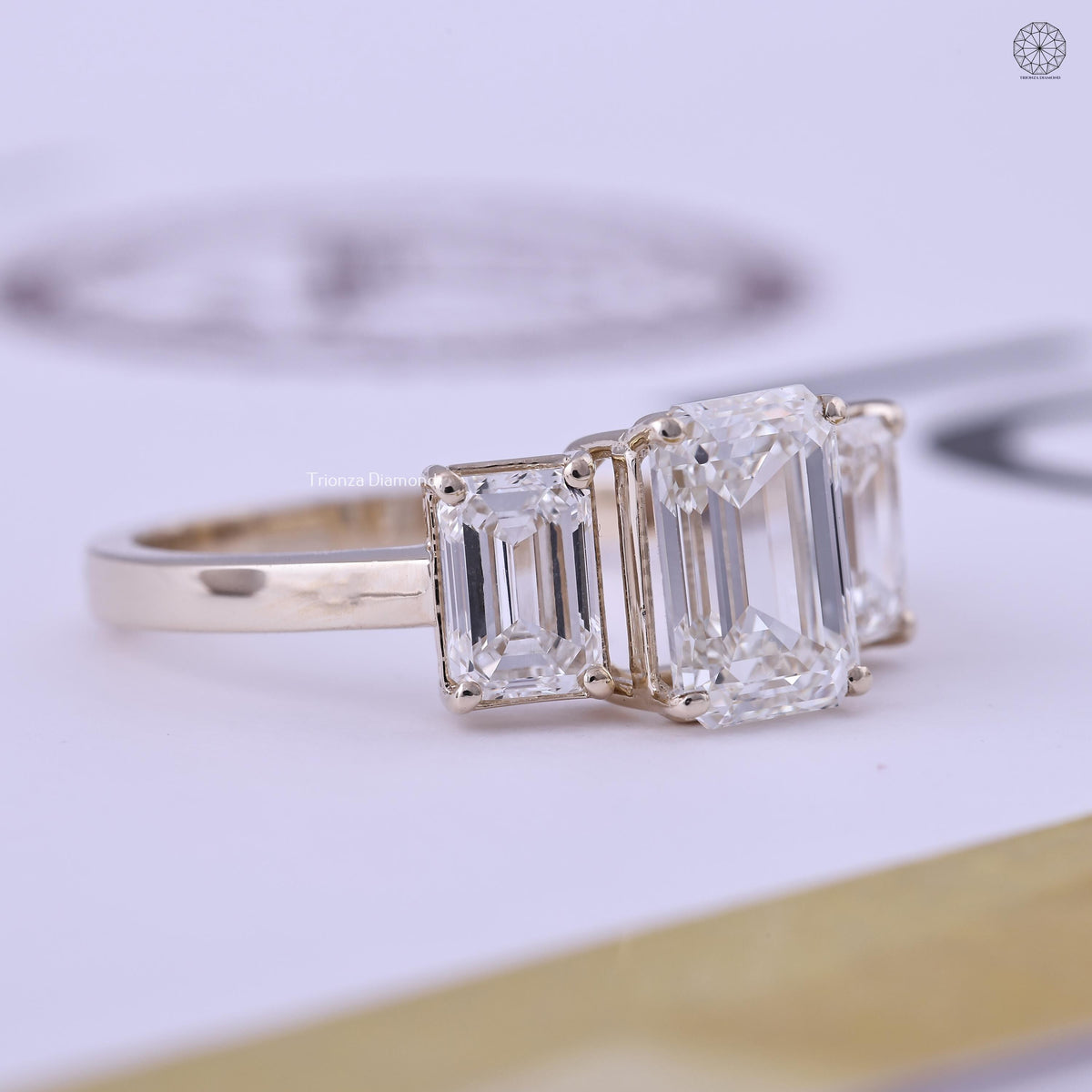 Close-up of the emerald cut center stone flanked by two matching emerald side stones