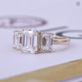 Trilogy engagement ring showcasing the 2 carat E color VS1 clarity emerald cut diamond