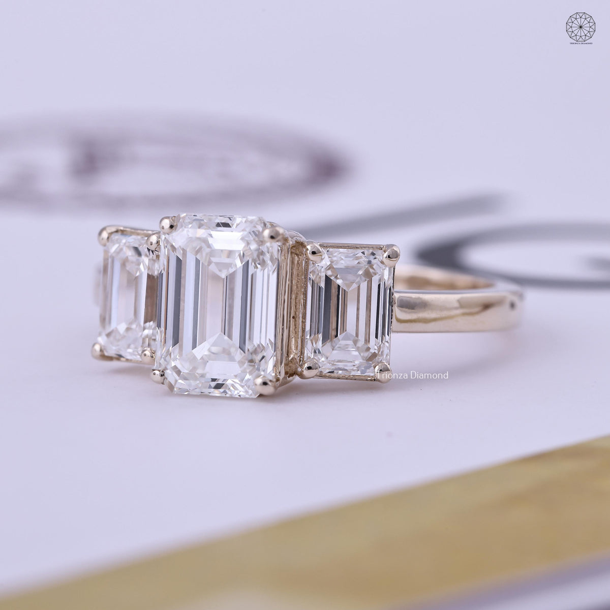 Trilogy engagement ring showcasing the 2 carat E color VS1 clarity emerald cut diamond