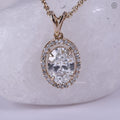 Close-up of the oval diamond halo pendant showing the solitaire setting details